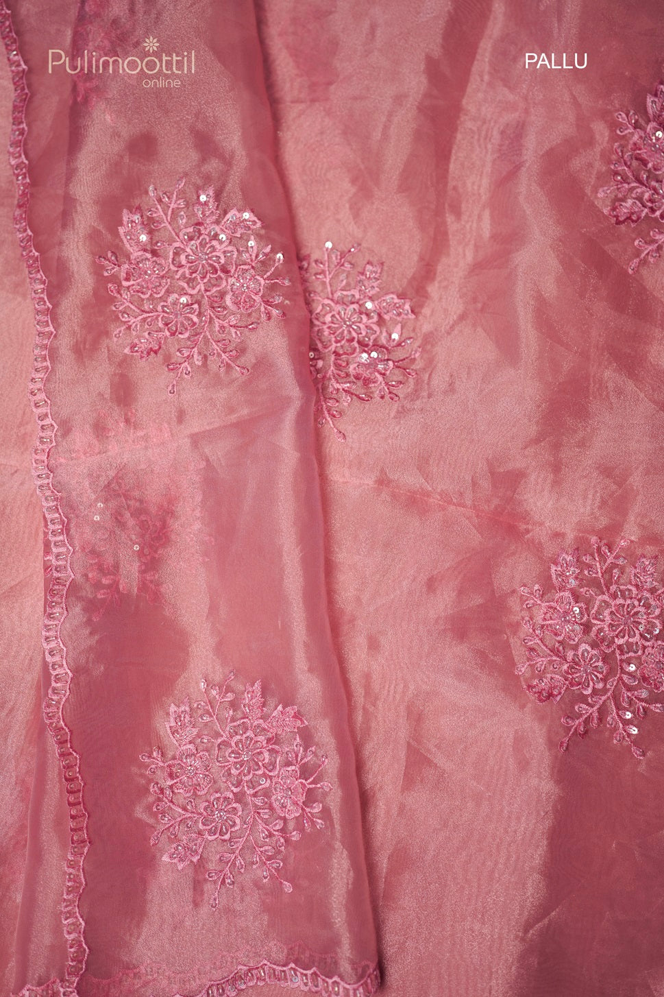 Close-up of light deep pink organza saree pallu with matching thread and sequins embroidery and scallop border, ideal for wedding and bridal occasions from Thrissur Pulimoottil Silks.