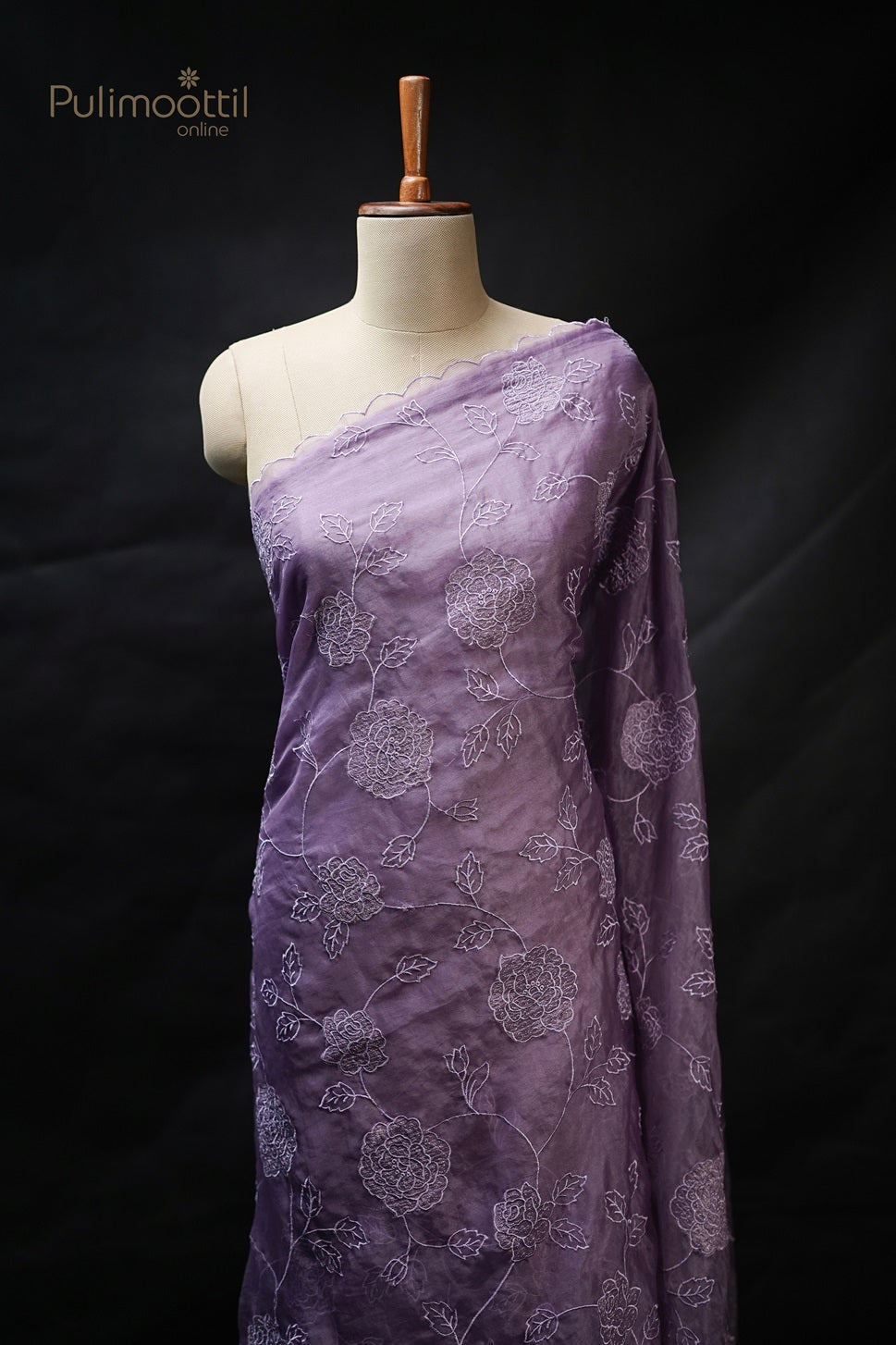 Lavender colour organza fancy saree draped on mannequin with delicate cut work and embroidery on body, featuring scallop border, from Thrissur Pulimoottil Silks, ideal for wedding and bridal sarees.