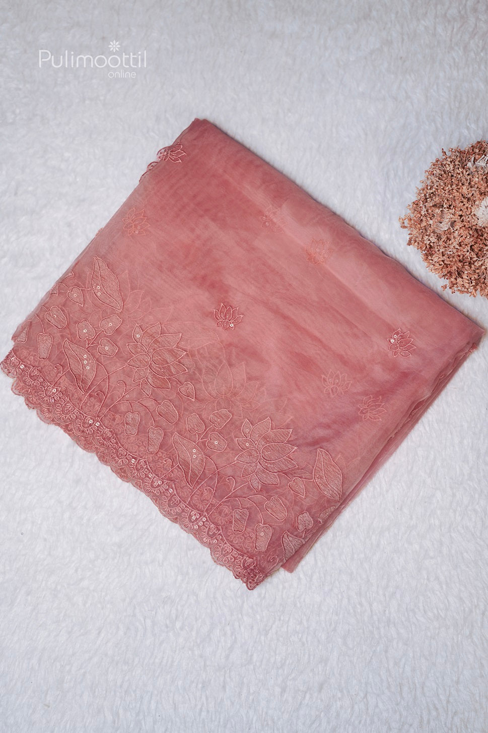 Folded peach organza fancy saree with small lotus buttas and lotus cut work scallop border, perfect for wedding and bridal occasions at Thrissur Pulimoottil Silks.